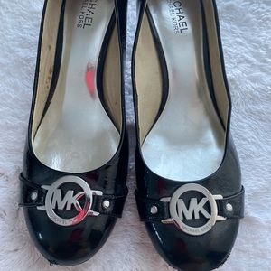 Used: Michael Kors 2 inch patent black heels with silver MK Buckle in the front